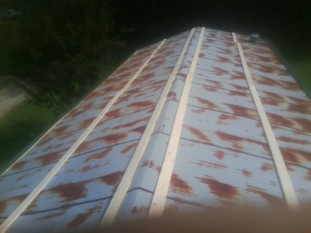 Rusted metal roof panels with new wood purlins before replacement — Storm Damage Roof Repair in Chapman by Roofing Brothers