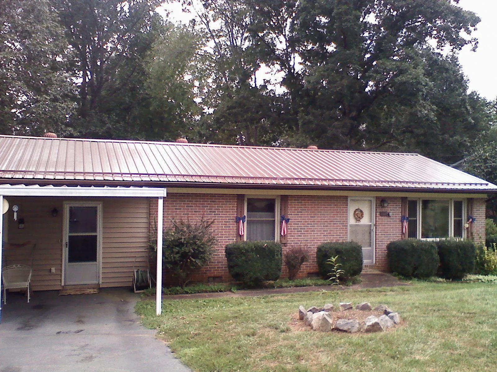 Bronze metal roof and carport on a brick ranch home — Roof Repair work by our crew in Chapman